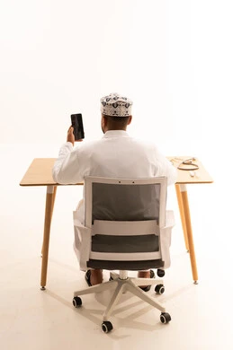 طبيب عماني يستخدم الهاتف الذكي في المكتب