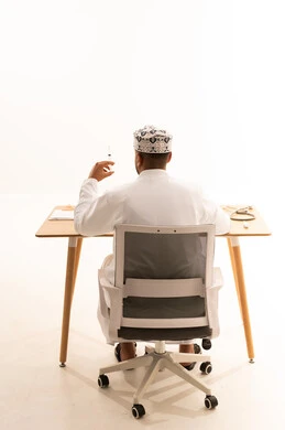 طبيب عماني يحمل حقنة طبية من الخلف
