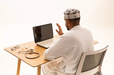 طبيب عماني يجري استشارة طبية عن بعد عبر الحاسوب