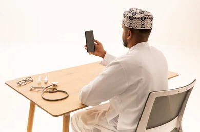 Omani Doctor in Traditional Dress Using Smartphone