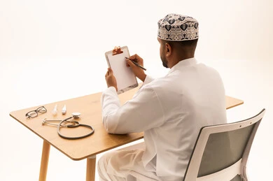 طبيب عماني يكتب ملاحظات طبية على المكتب
