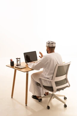 Omani Man Working on Laptop in Traditional Dress