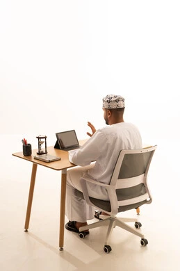 Omani Man Working at Office Desk with Tablet