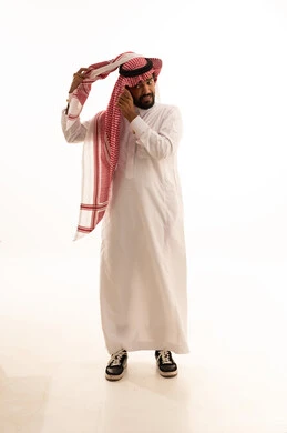 Saudi Man Adjusting Traditional Shemagh on White Background