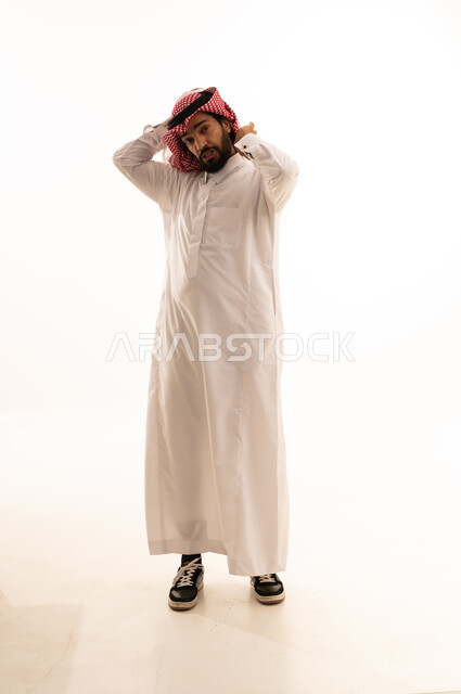 رجل سعودي يرتدي الثوب والشماغ في استوديو أبيض