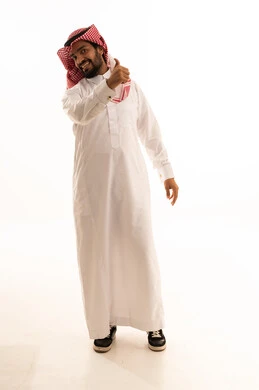 رجل سعودي بالزي التقليدي يشير بعلامة الإعجاب