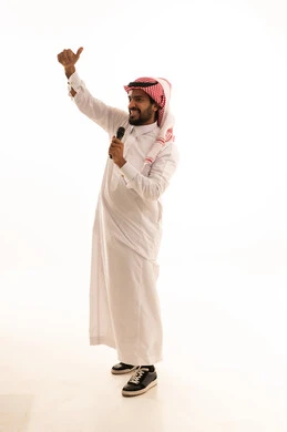 رجل سعودي يحمل ميكروفون ويرفع إبهامه خلفية بيضاء