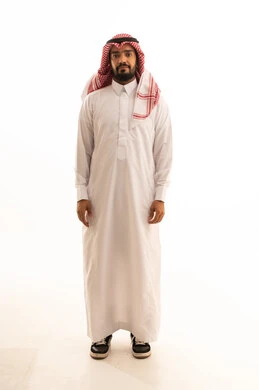 رجل سعودي بالزي التقليدي أمام خلفية بيضاء