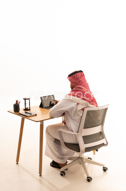 Saudi Man Using Tablet at Office Desk White Background