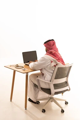 Saudi Medical Professional Using Laptop at Office Desk
