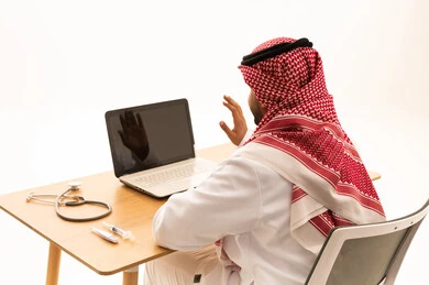 Saudi Doctor Using Laptop for Online Medical Consultation