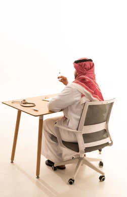 طبيب سعودي بالزي التقليدي يحمل حقنة طبية