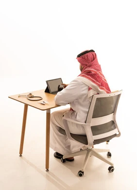 طبيب سعودي يستخدم جهازاً لوحياً في مكتبه