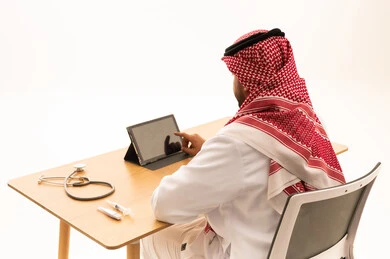 طبيب سعودي يستخدم جهازاً لوحياً في العيادة