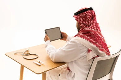 Saudi Physician Using Digital Tablet in Medical Office