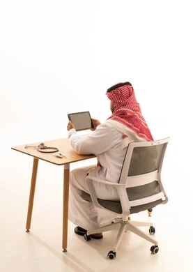 طبيب سعودي مع جهاز لوحي من الخلف