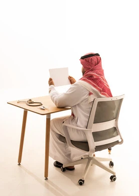 Saudi Doctor in Traditional Thobe at Office Desk