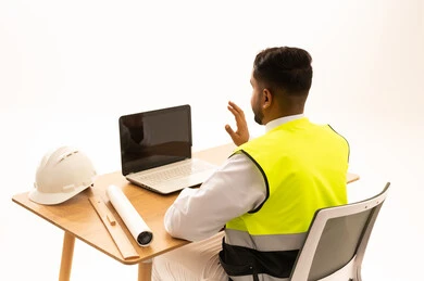Arab Engineer in Safety Vest Working on Laptop