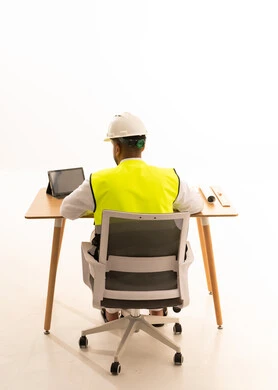 Saudi Engineer in Safety Gear at Office Desk Back View
