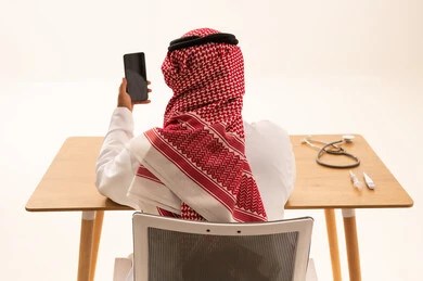 Saudi Doctor Using Smartphone with Medical Equipment