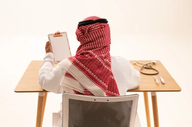 Saudi Arabian Doctor at Desk with Medical Equipment