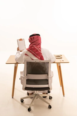 طبيب سعودي يجلس خلف المكتب مع لوحة ملاحظات