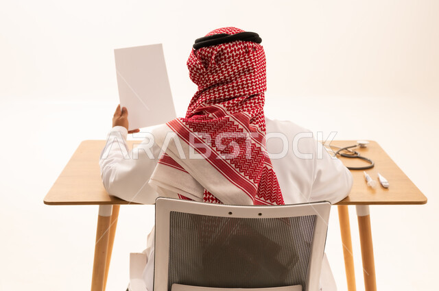 طبيب سعودي بالزي التقليدي في مكتبه
