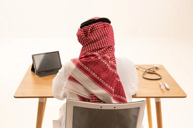 Saudi Male Doctor in Traditional Attire at Medical Desk
