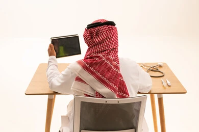 طبيب سعودي يستخدم جهاز لوحي في العيادة الطبية