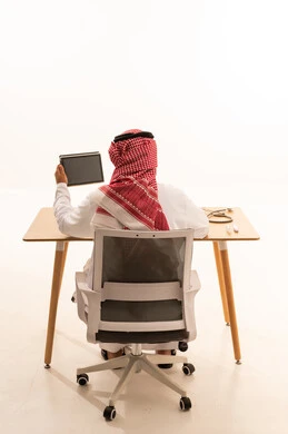 Saudi Doctor Holding Tablet at Office Desk Back View