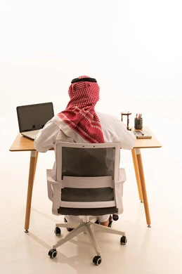 Saudi Man in Traditional Thobe at Office Desk Back View