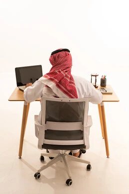 Saudi Man Working on Laptop at Minimalist Desk