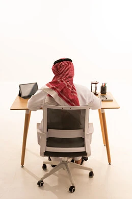 Saudi Man in Traditional Dress Working at Office Desk