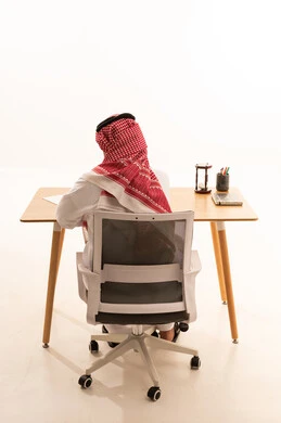 Saudi Man in Traditional Thobe Working at Office Desk