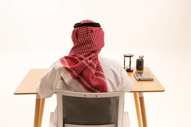 Saudi Man Sitting at Office Desk Rear View