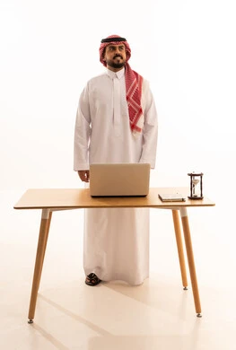 Saudi Businessman in Traditional Dress Standing at Desk