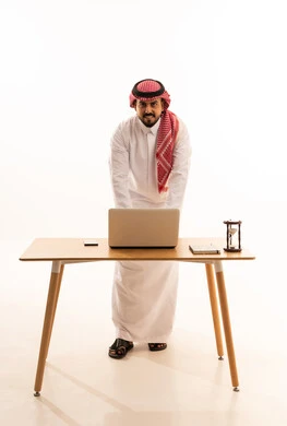 Saudi Man Working on Laptop in Studio White Background