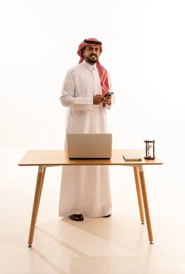Saudi Businessman with Laptop and Smartphone in Office