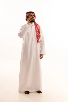 رجل سعودي يتحدث عبر الهاتف المحمول بخلفية بيضاء