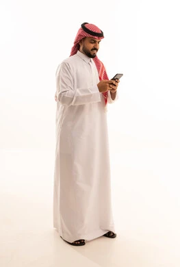 Saudi Man in Traditional Thobe Using Smartphone
