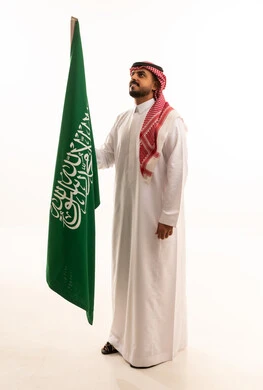Saudi Man Holding Saudi Arabian Flag in Studio