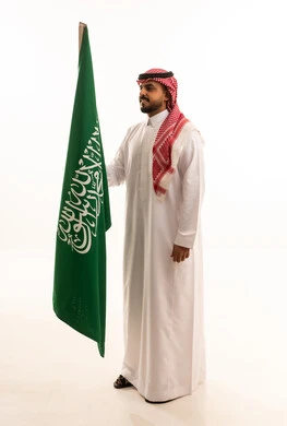 Saudi Man in Traditional Thobe Holding National Flag