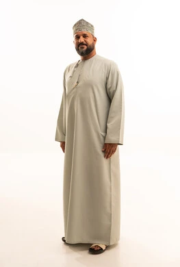 Omani Man in Traditional Dishdasha and Kumma Cap