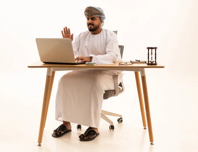 Omani Man in Traditional Dress Working on Laptop