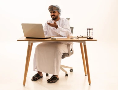 Omani Man in Traditional Dress Working on Laptop