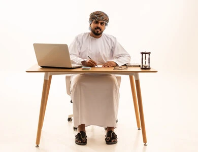 رجل أعمال عُماني يعمل على اللابتوب في المكتب