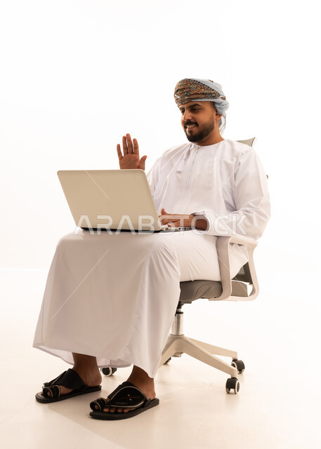 رجل أعمال عماني يستخدم اللاب توب في مكالمة فيديو