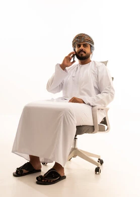Omani Man in Traditional Dress Talking on Smartphone