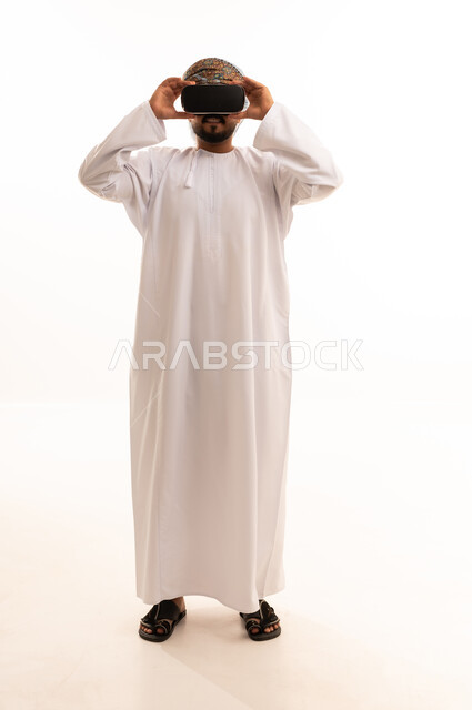 Omani Man Wearing Kumma Using VR Headset on White Background