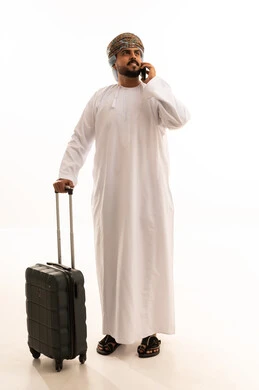 Omani Man with Suitcase Talking on Phone